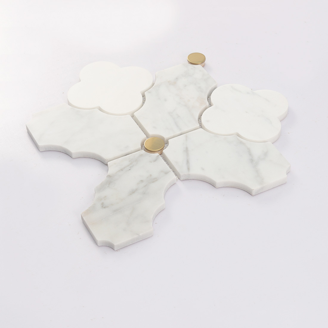 Angled view of white marble arabesque mosaic tile with gold round dots
