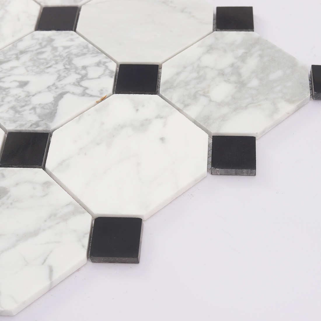 Side view of white marble octagon mosaic tile with black dot accents
