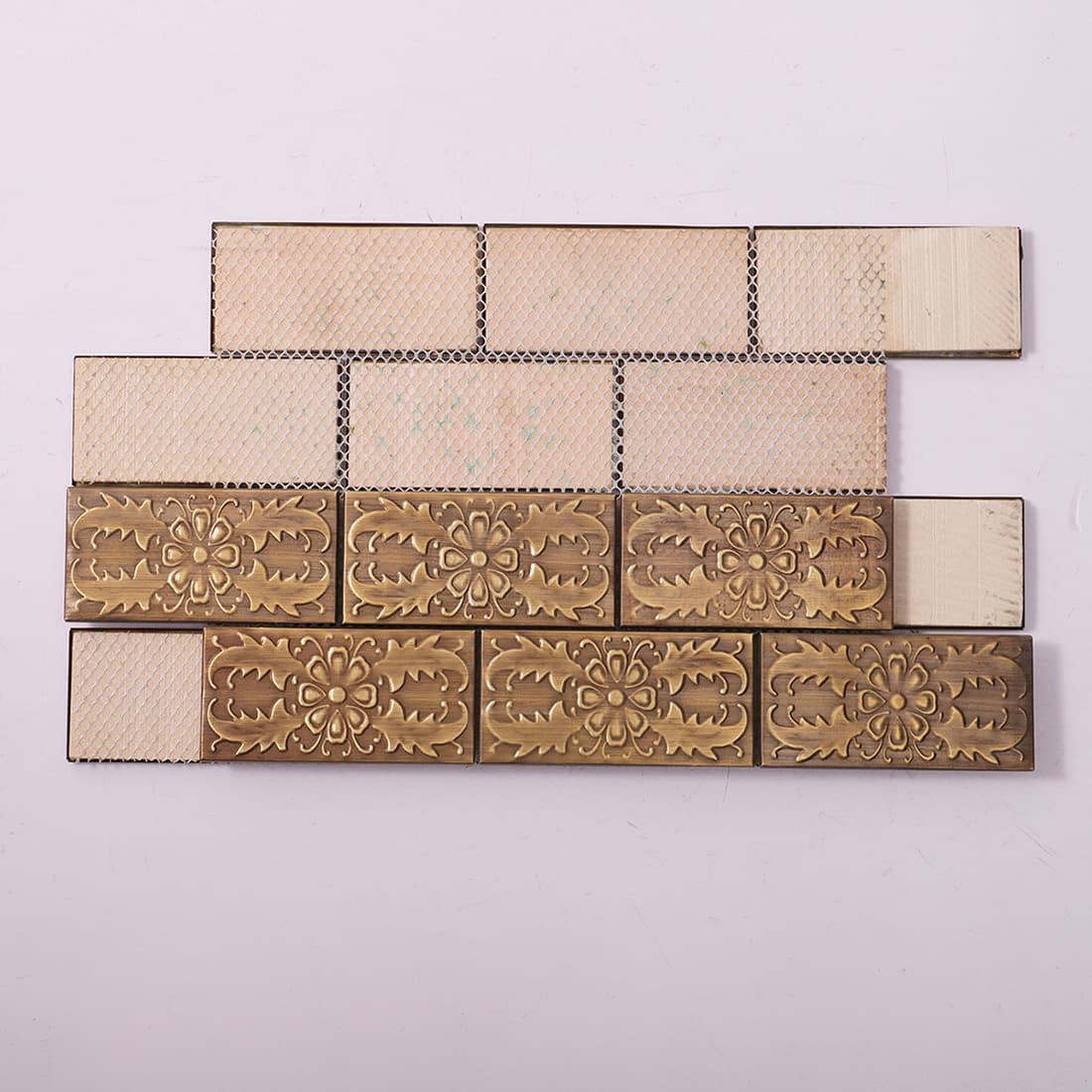 Back view of antique brass floral embossed metal mosaic tile with mesh