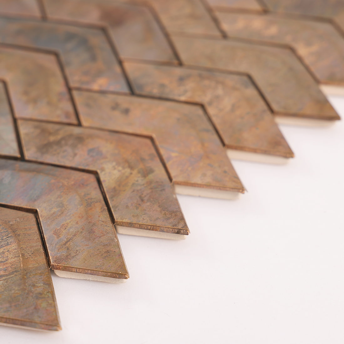 Edge detail of antique copper chevron metal mosaic tile