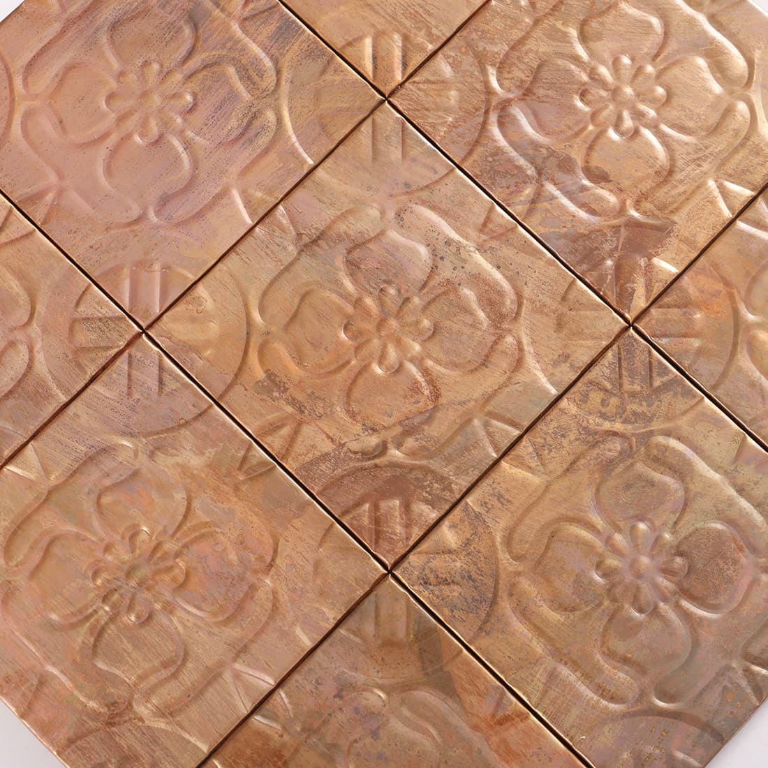 Close up of antique copper embossed floral mosaic tile pattern