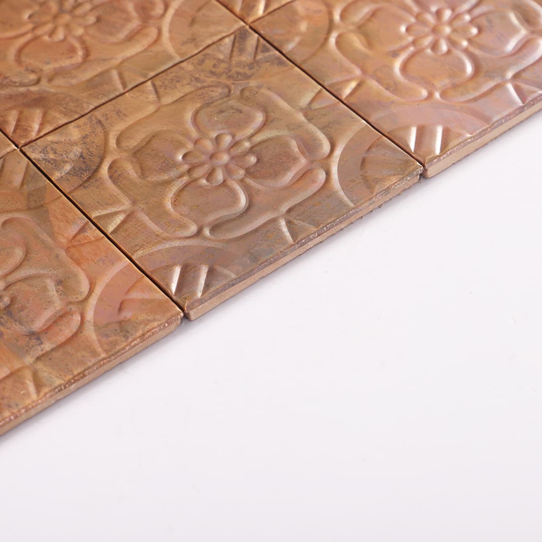 Side view of antique copper embossed floral mosaic tiles