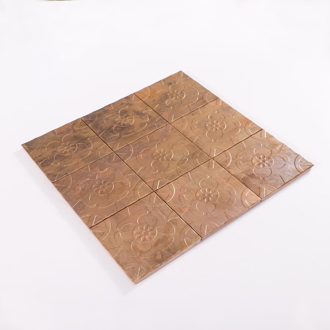 Angled view of antique copper floral embossed mosaic sheet