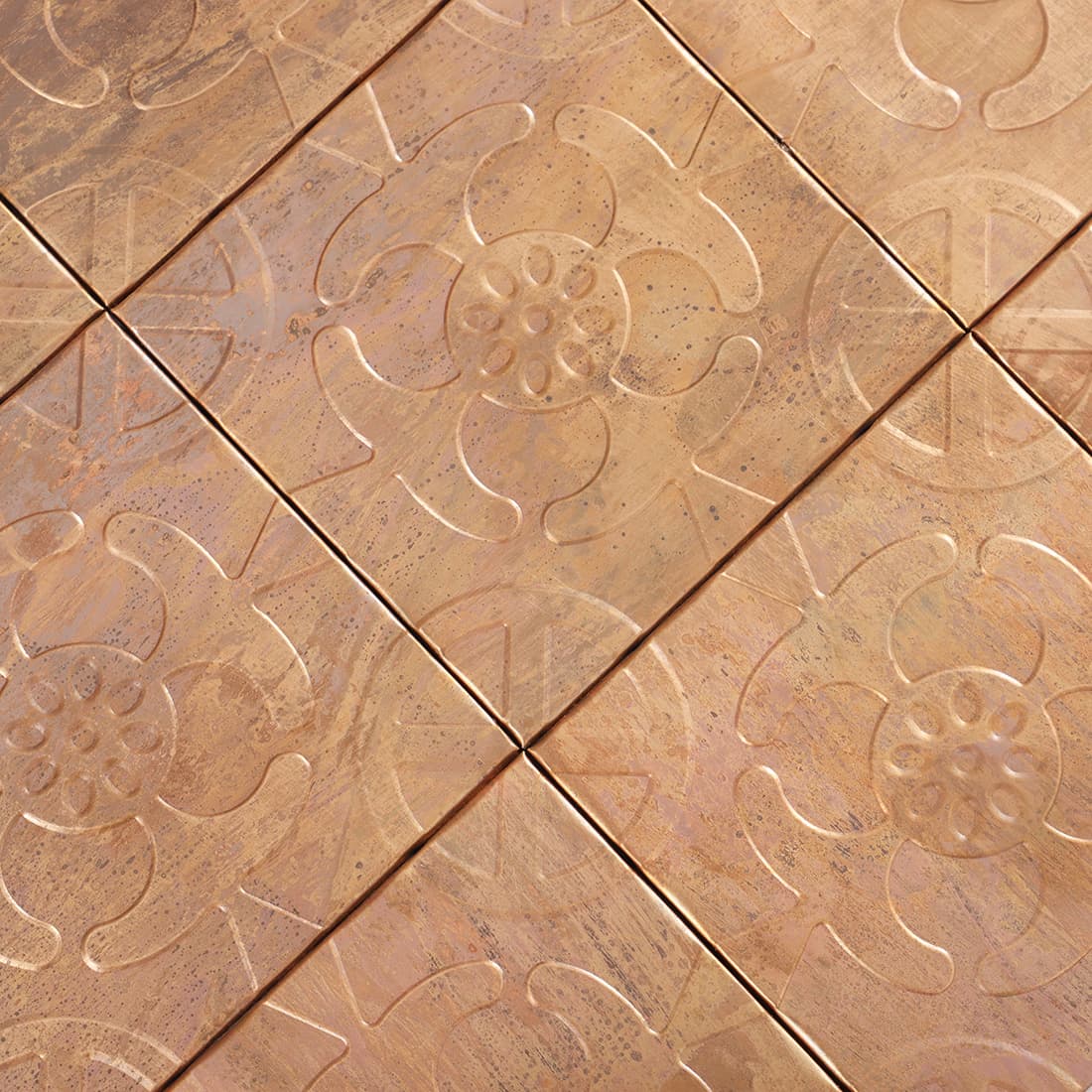 Close up of antique copper floral embossed mosaic tile pattern