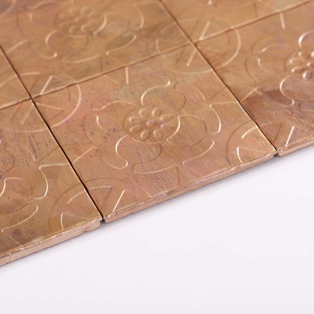 Side view of antique copper floral embossed mosaic tiles