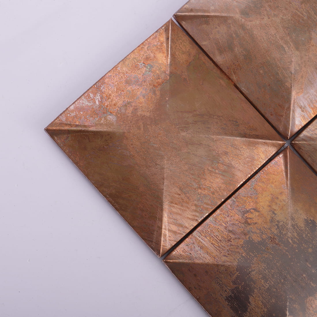 Corner detail of antique copper square 3D metal mosaic tile