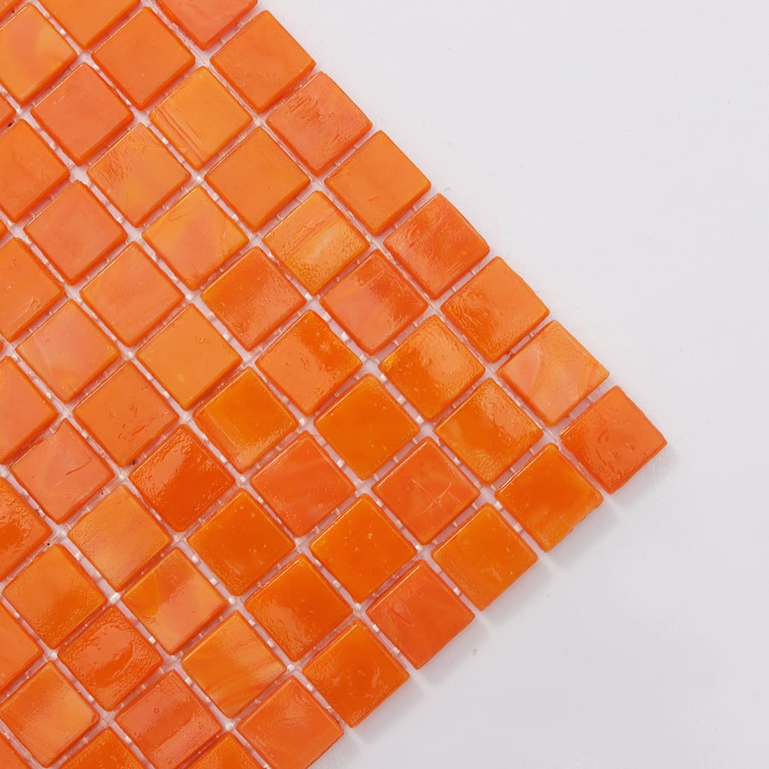 Corner close-up of apricot orange square glass mosaic tile