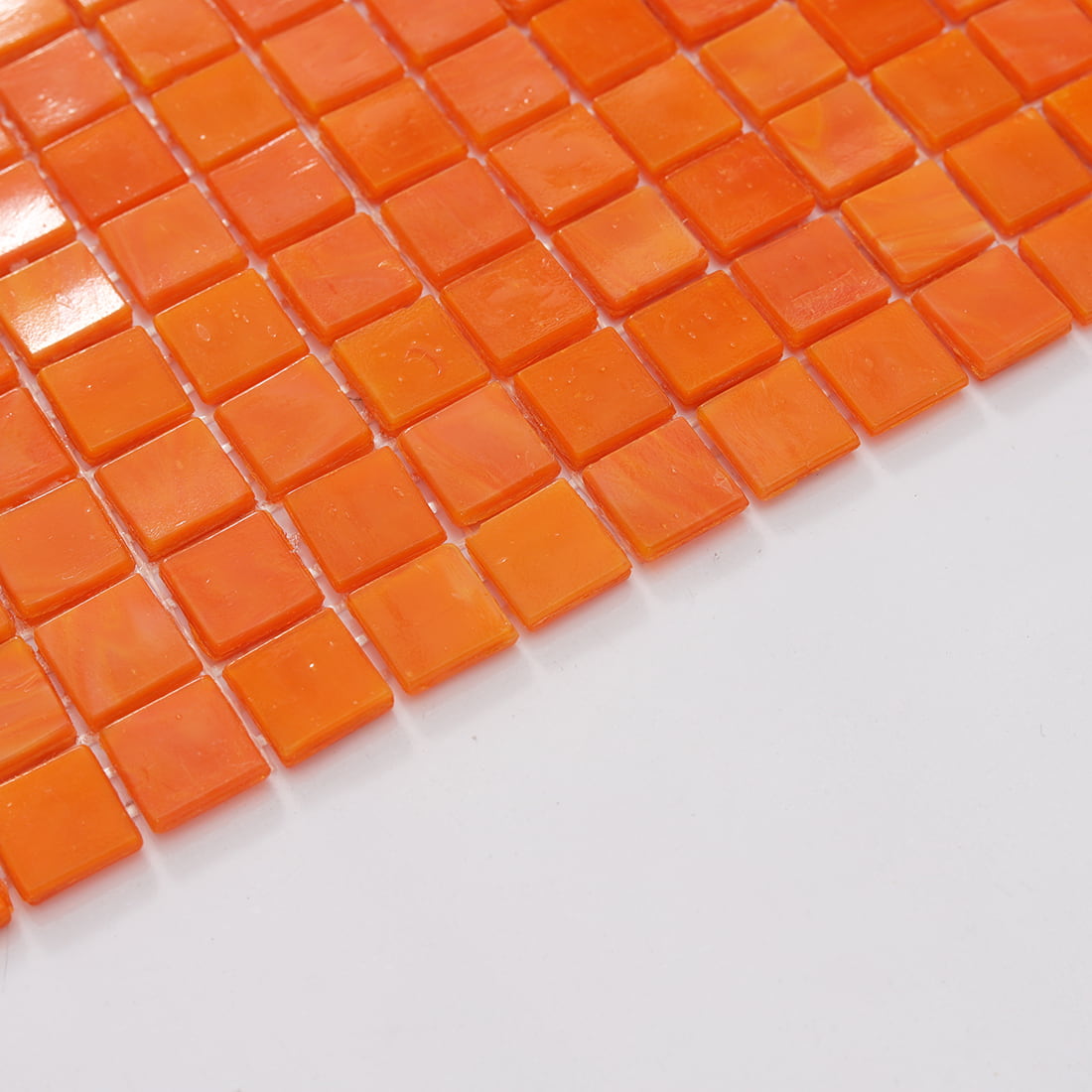 Edge close-up of apricot orange square glass mosaic tile