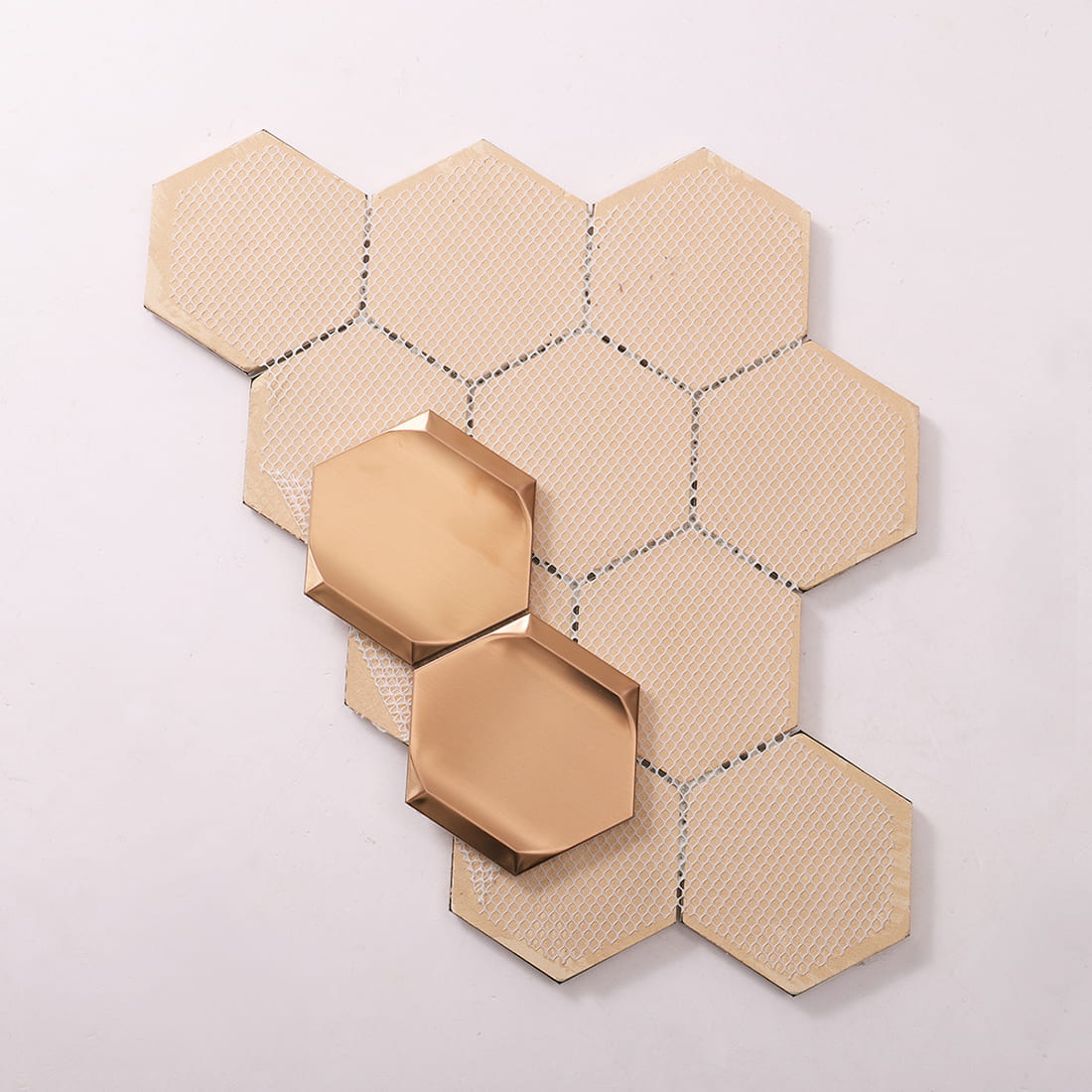 Back mesh view of rose gold hexagon metal mosaic tile with loose pieces
