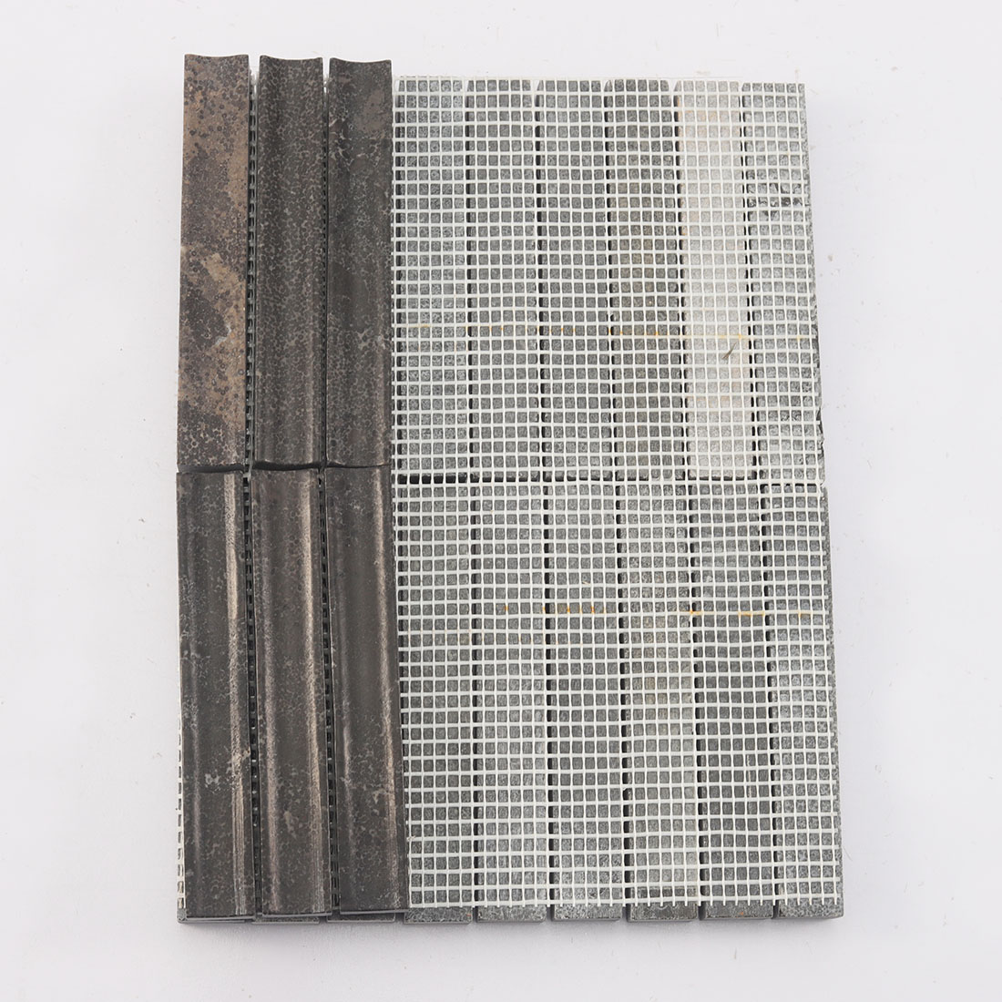 Back view of a fluted linear stone mosaic tile sheet showing the fiber mesh grid.