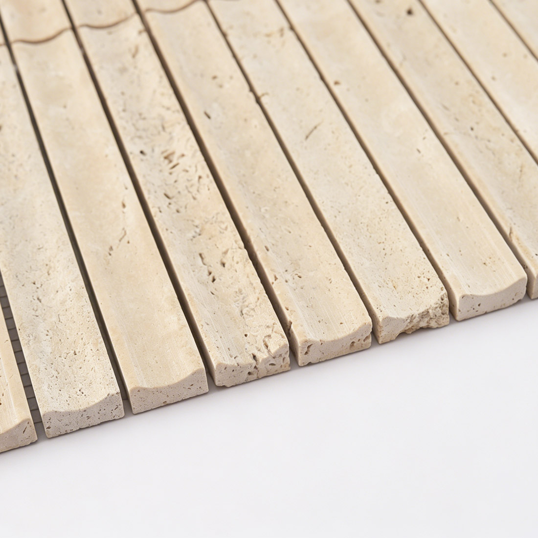 Edge profile view of beige fluted travertine tile.
