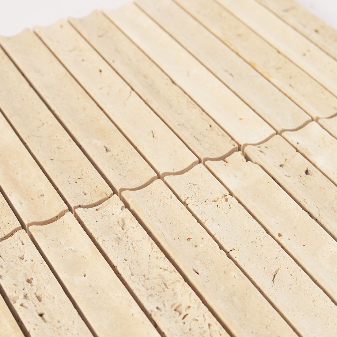Surface texture and grout lines of fluted travertine.