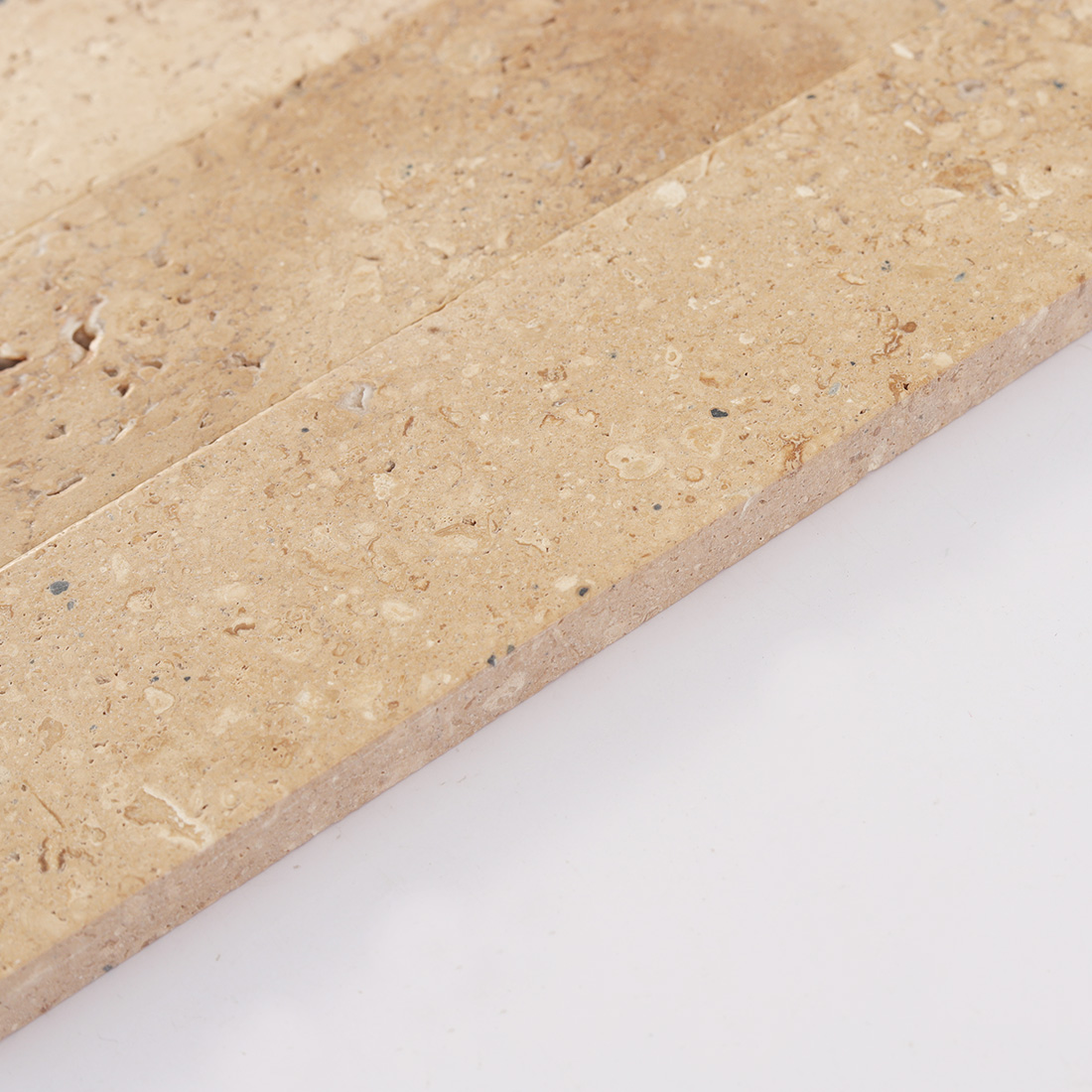 Side view of beige marble tile showing natural stone depth and color