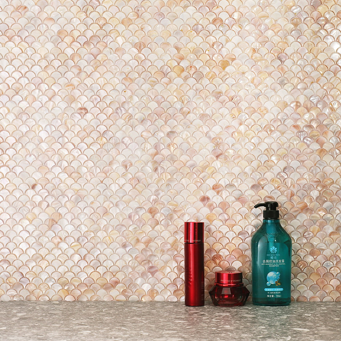 installed beige mother of pearl fan mosaic tile on wall with countertop and bottles