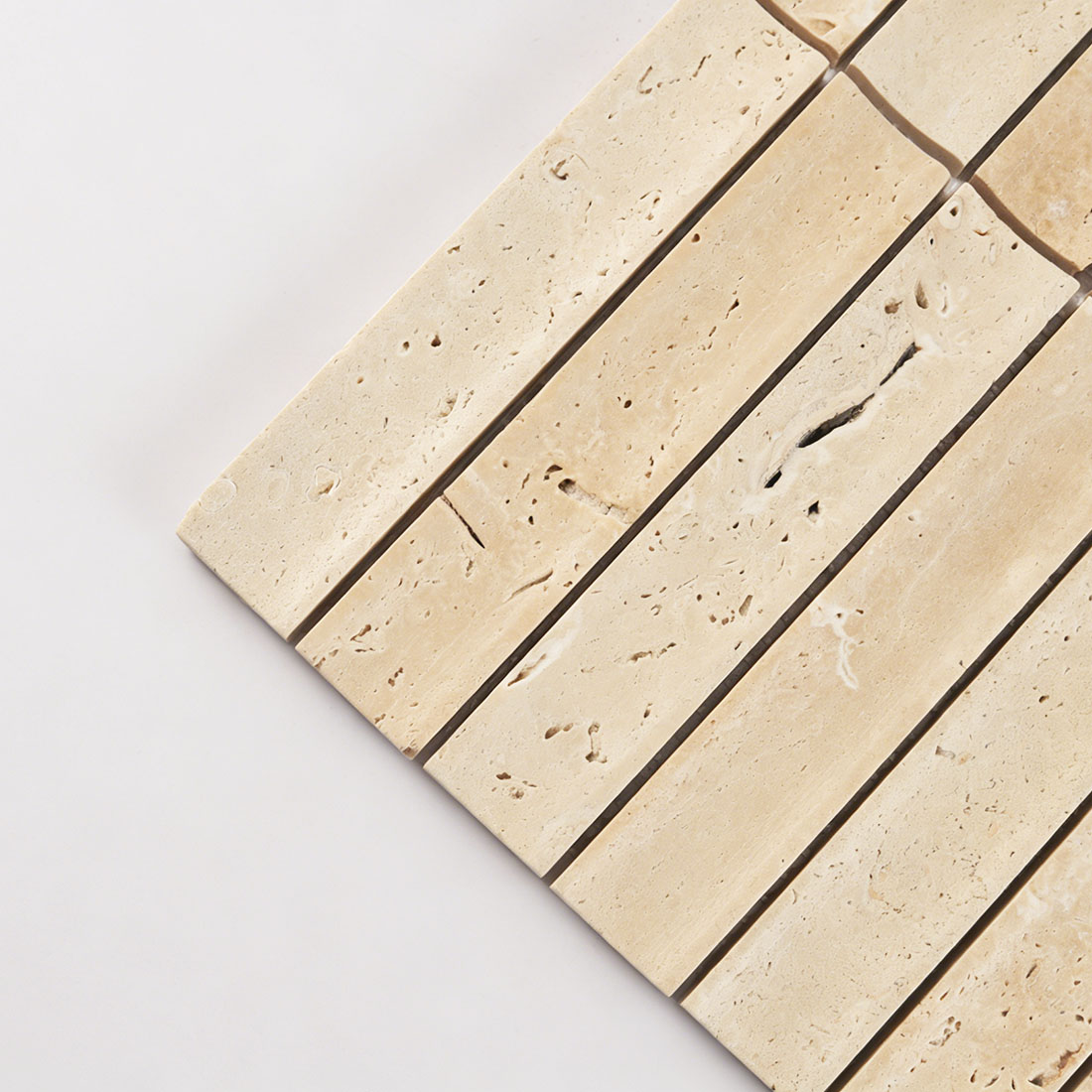 Corner detail showing curved beige travertine fluted tile.