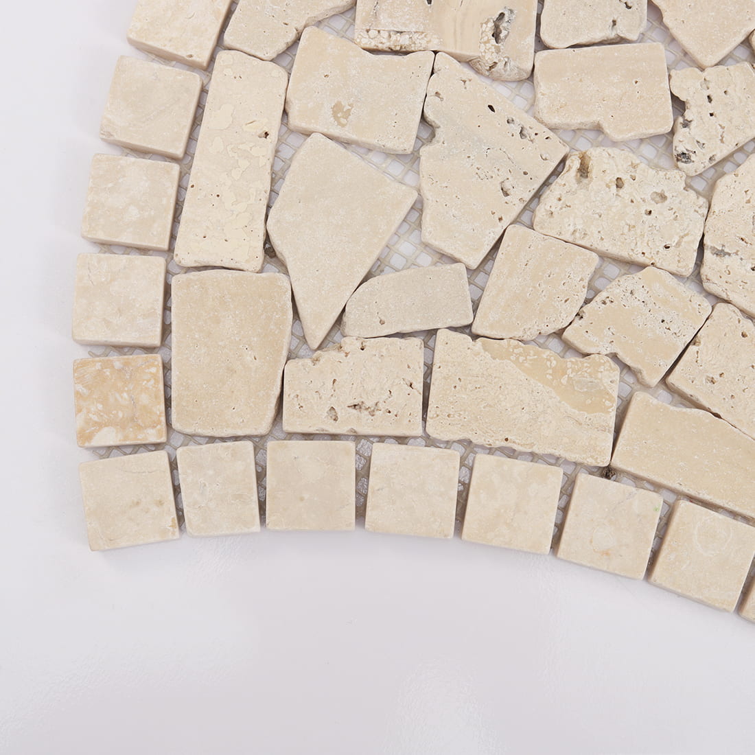 Corner detail of beige travertine irregular mosaic with curved border