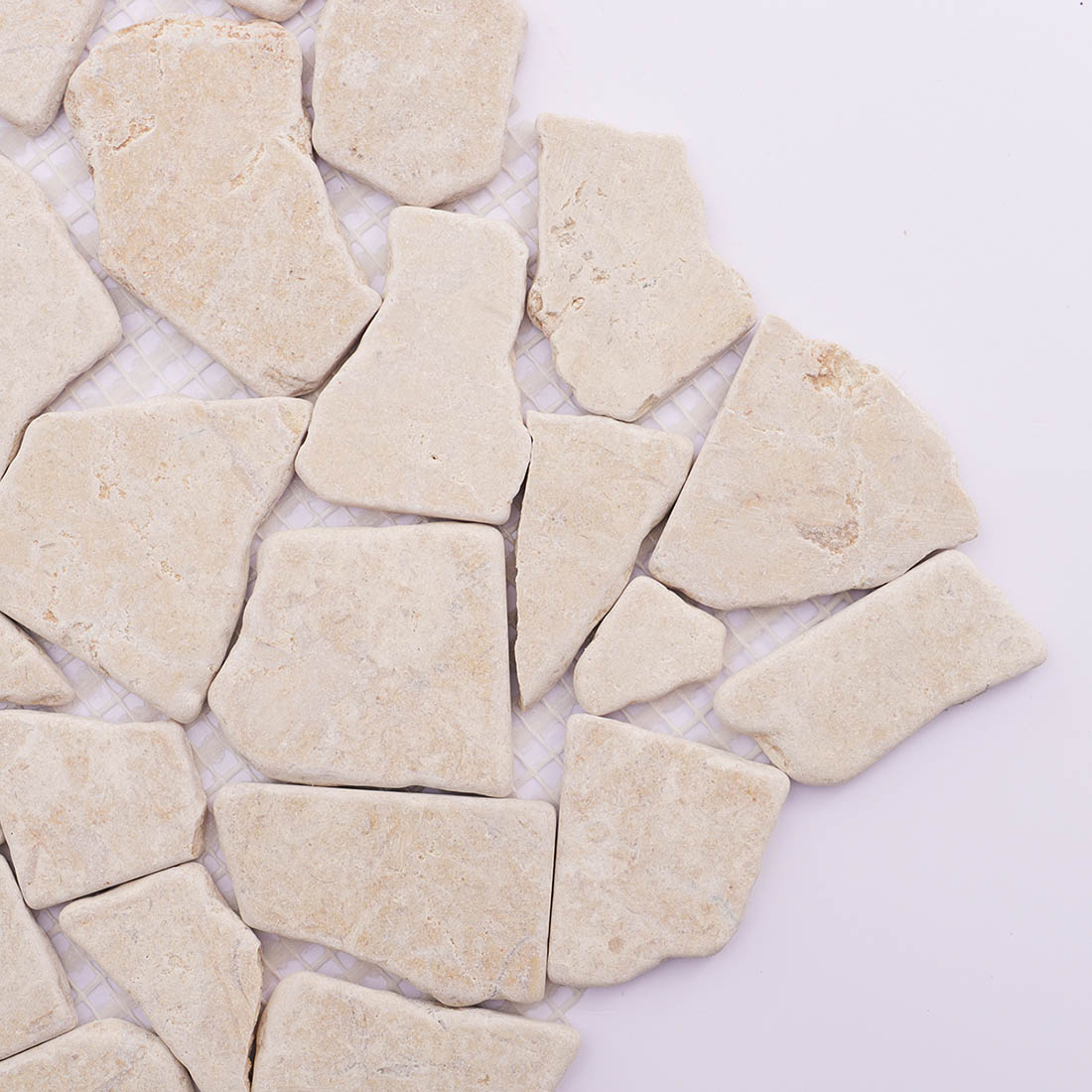 Close-up beige travertine irregular mosaic tile with rustic edges.