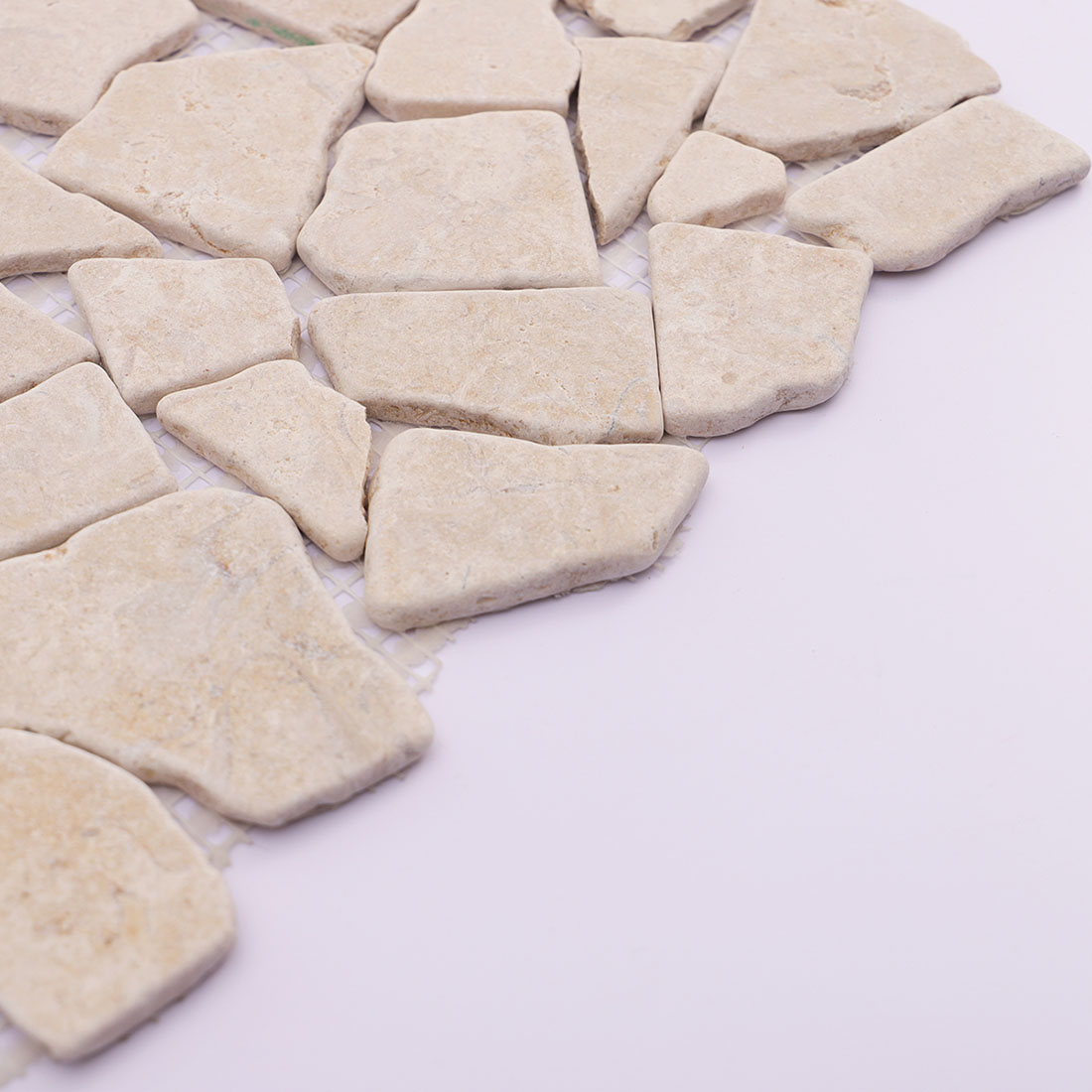 Side view of beige travertine irregular mosaic tile showing thickness.