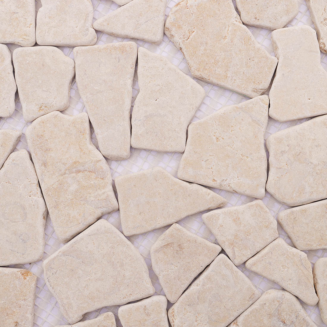 Beige travertine random mosaic tile close-up with soft natural texture.
