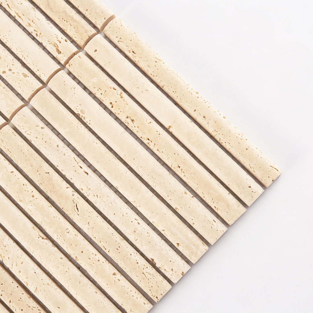 Close-up corner detail showing the rod texture of beige travertine tile.