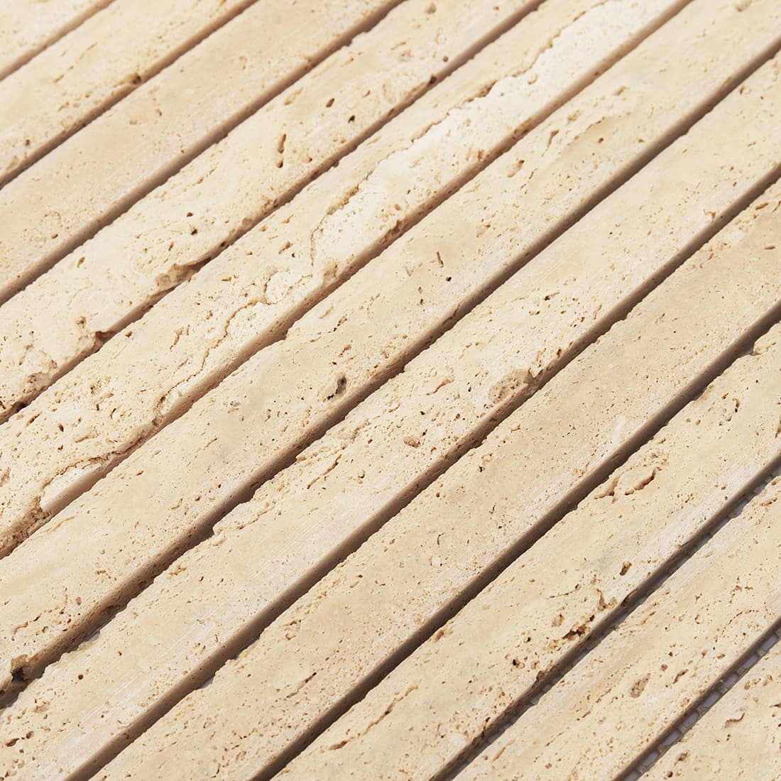 Close-up of beige travertine rounded strip mosaic tile surface