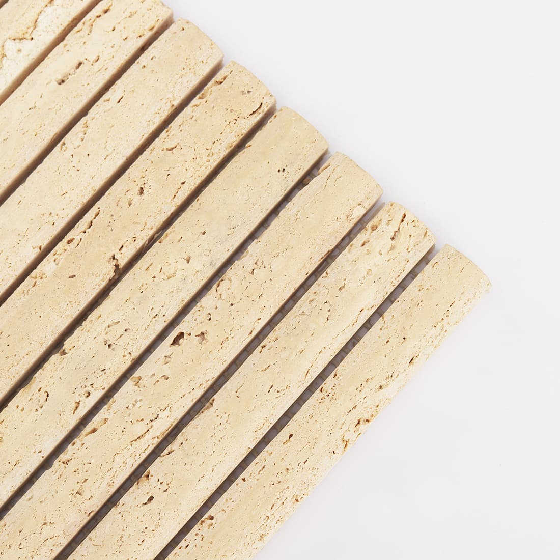 Corner detail of beige travertine rounded strip mosaic tile