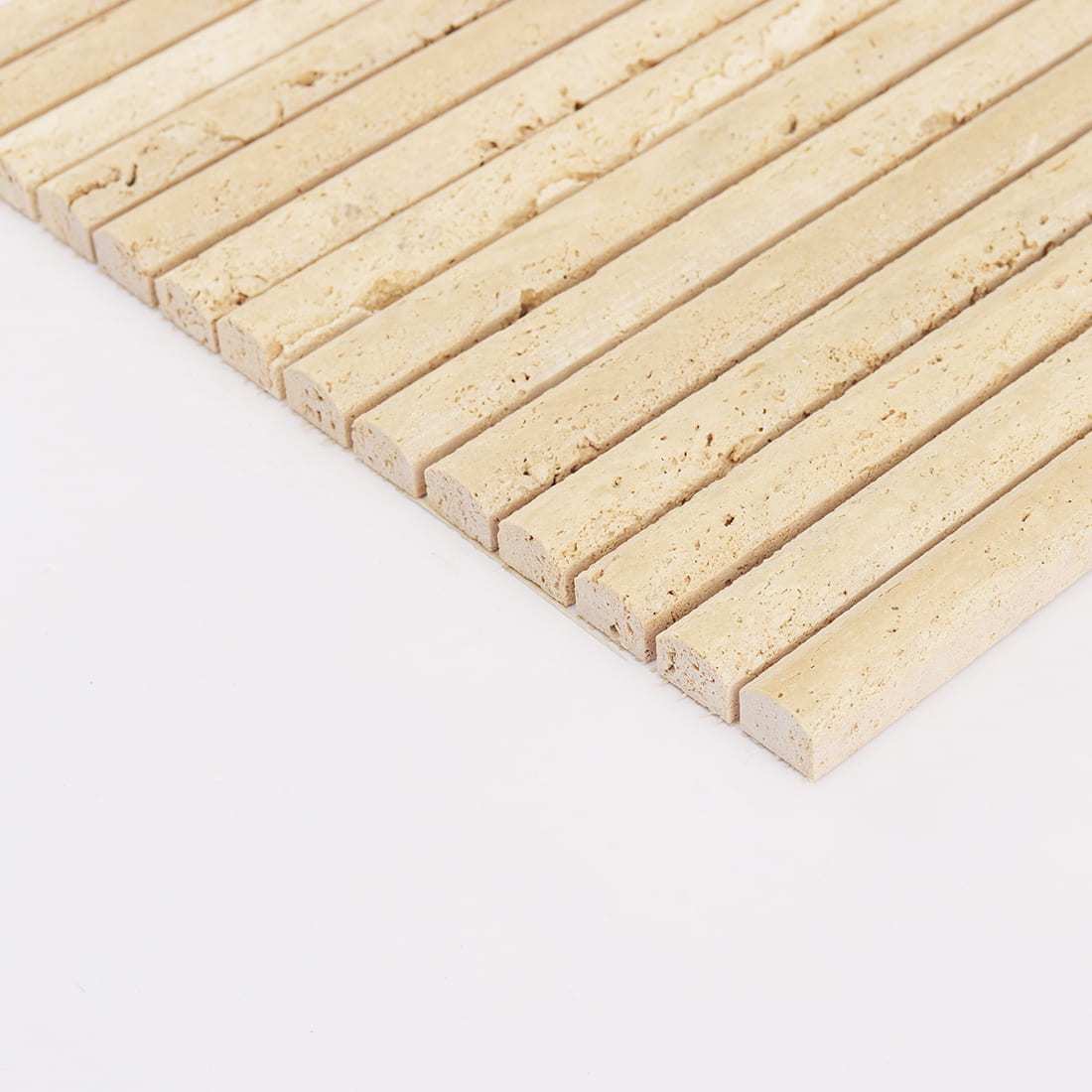 Angled edge view of beige travertine rounded strip mosaic tile
