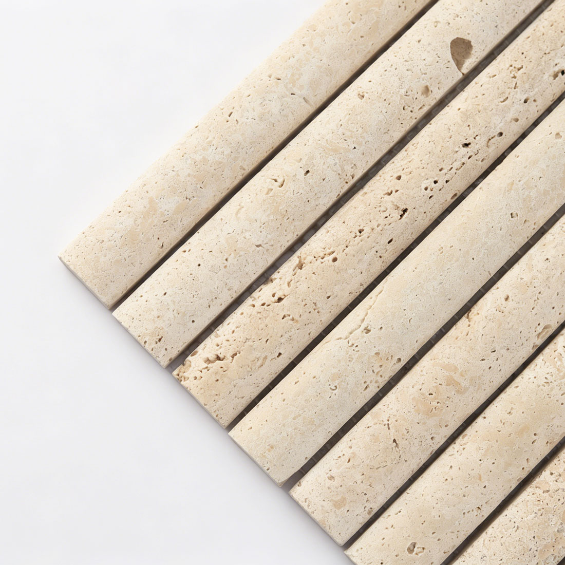 Close-up corner detail showing tubular contour of beige travertine tile.