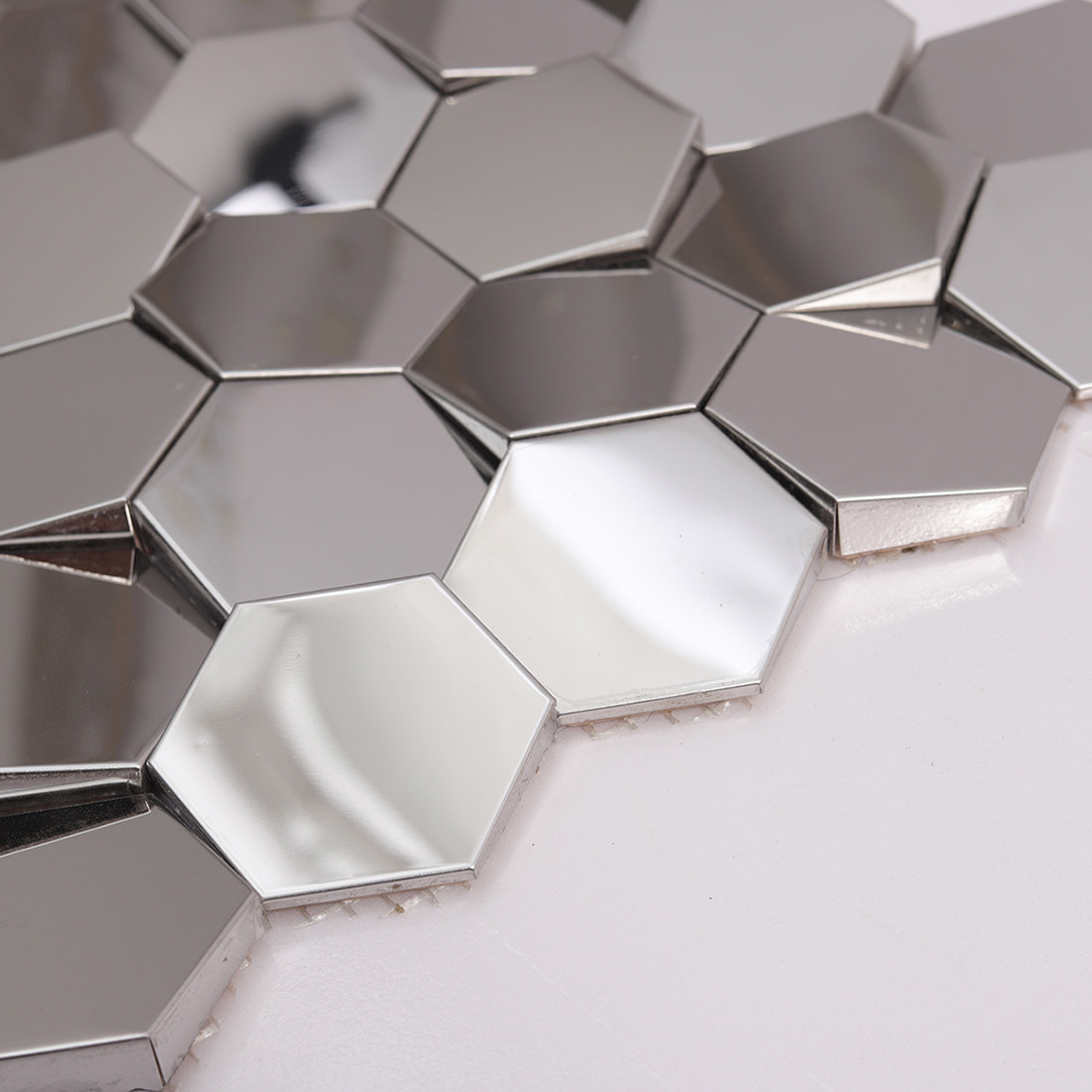 Edge detail of beveled silver mirror hexagon metal mosaic tile