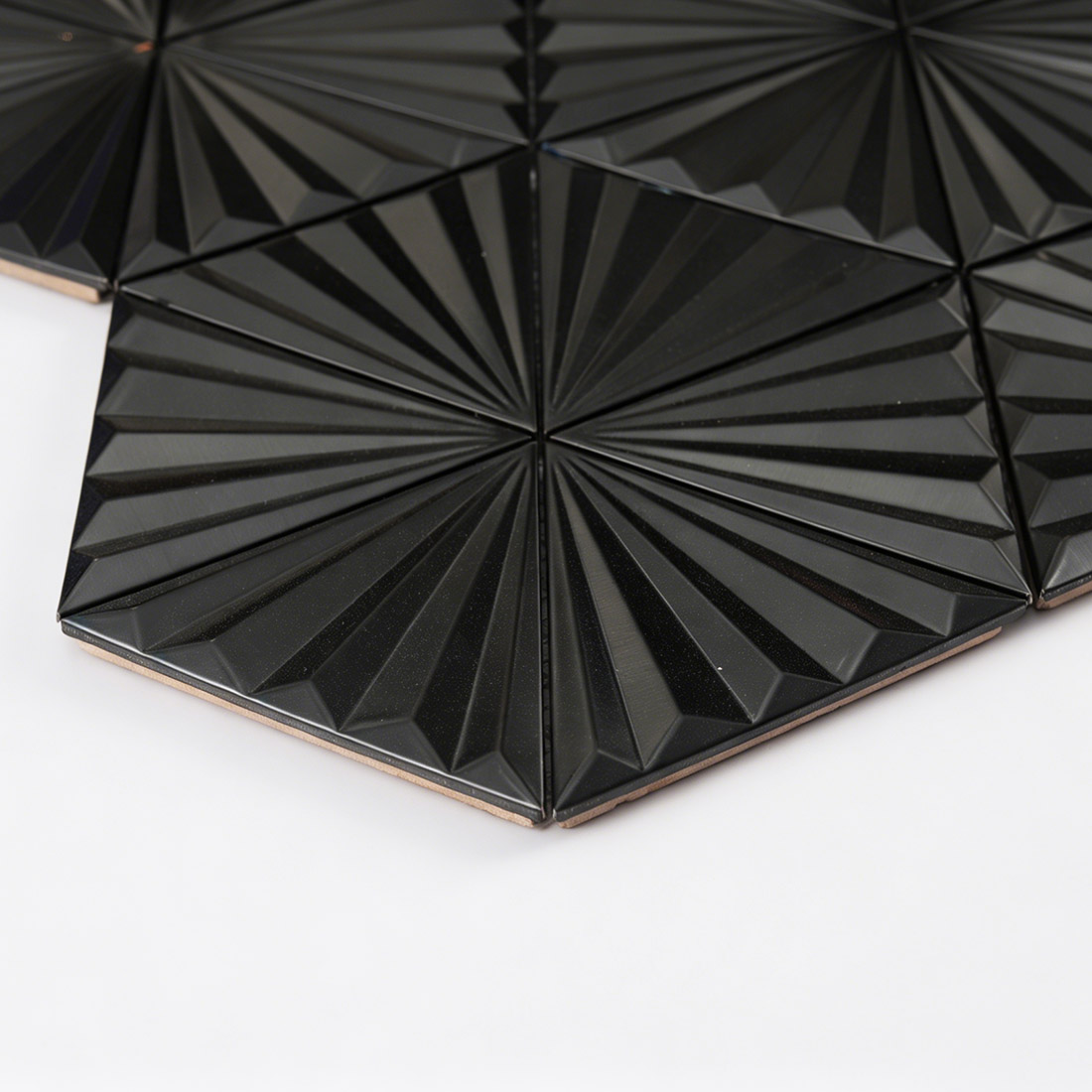 Side detail of black 3D triangle metal mosaic showing tile thickness
