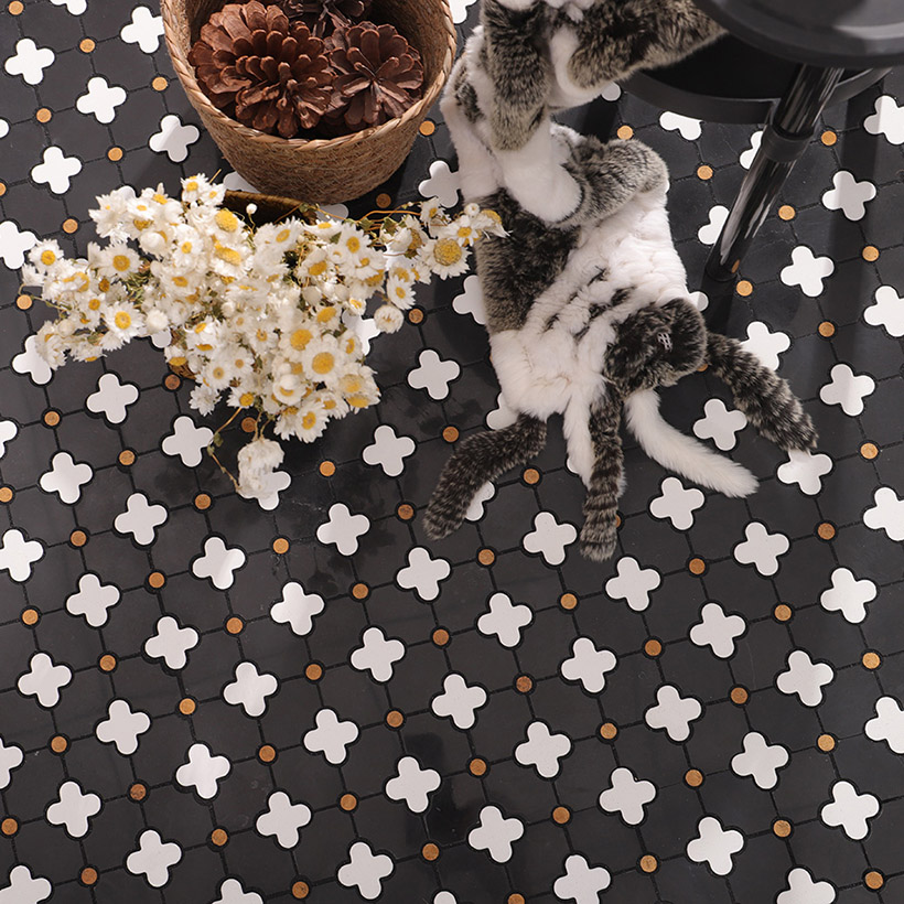 {"default":"Black mosaic floor with white floral patterns and decorative items placed on top"}
