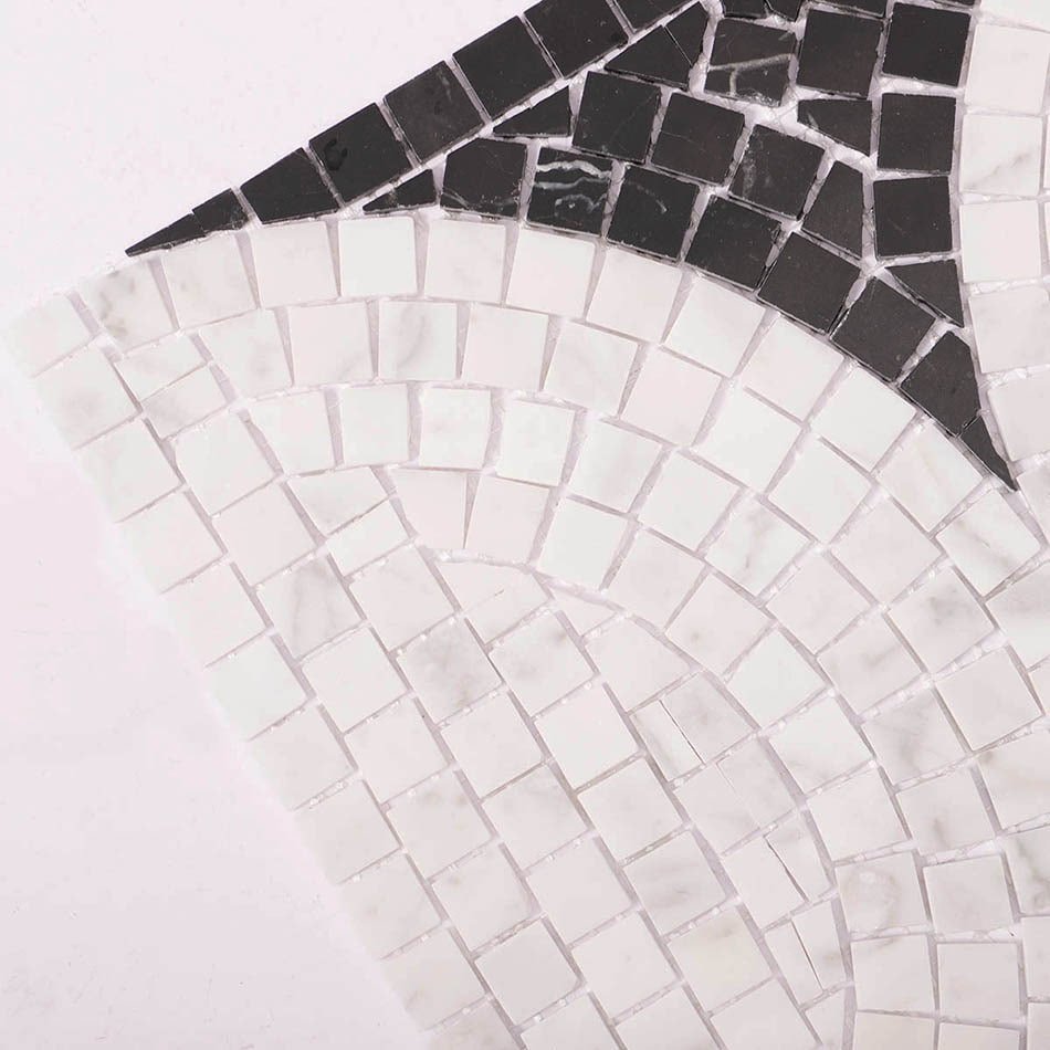 Close-up of black and white marble mosaic tile with curved arc design.