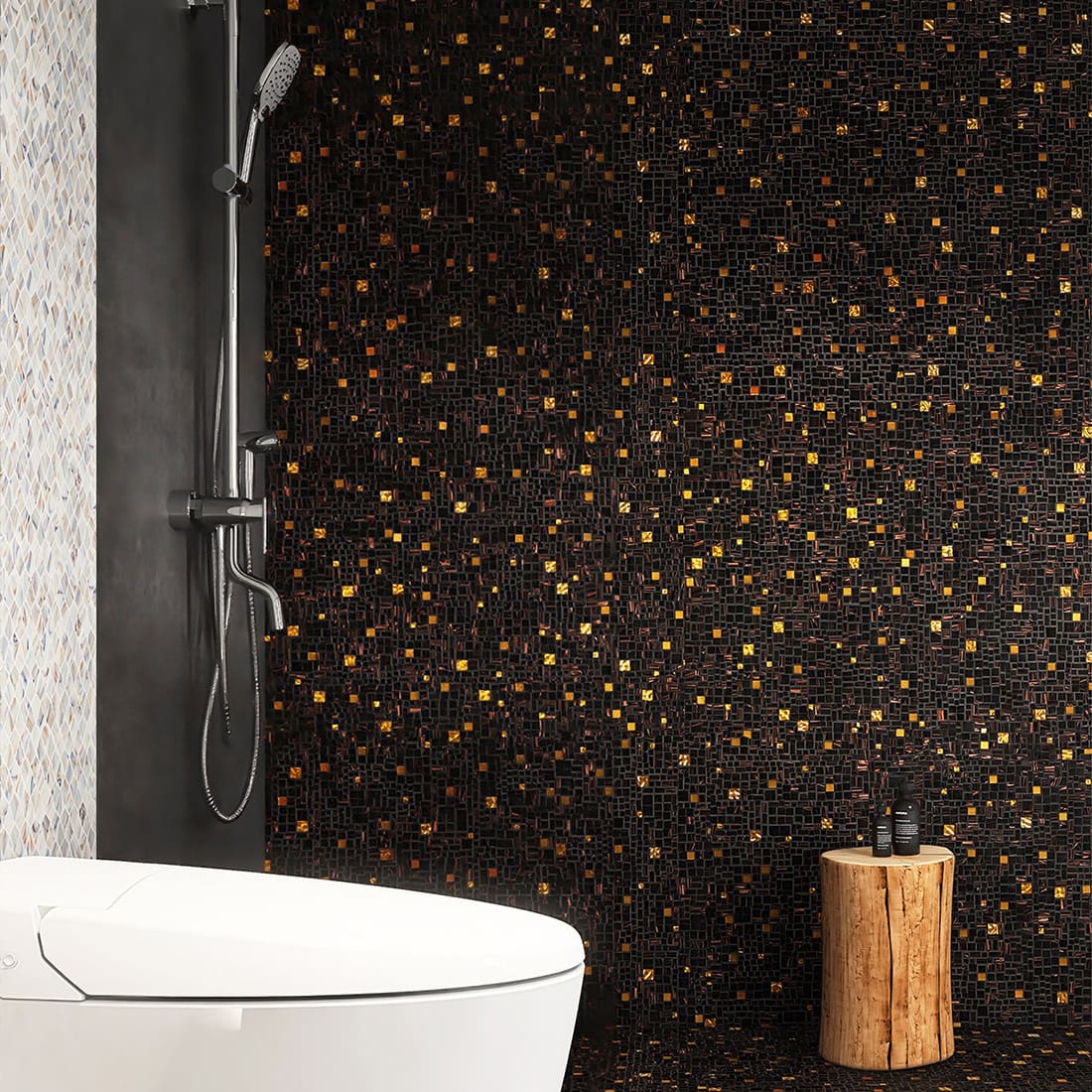 Black gold mosaic bathroom wall and floor beside a modern white fixture