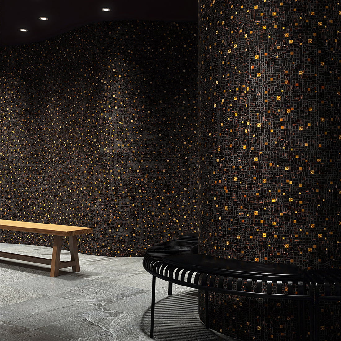Black gold mosaic wall cladding wrapping curved columns in a modern interior