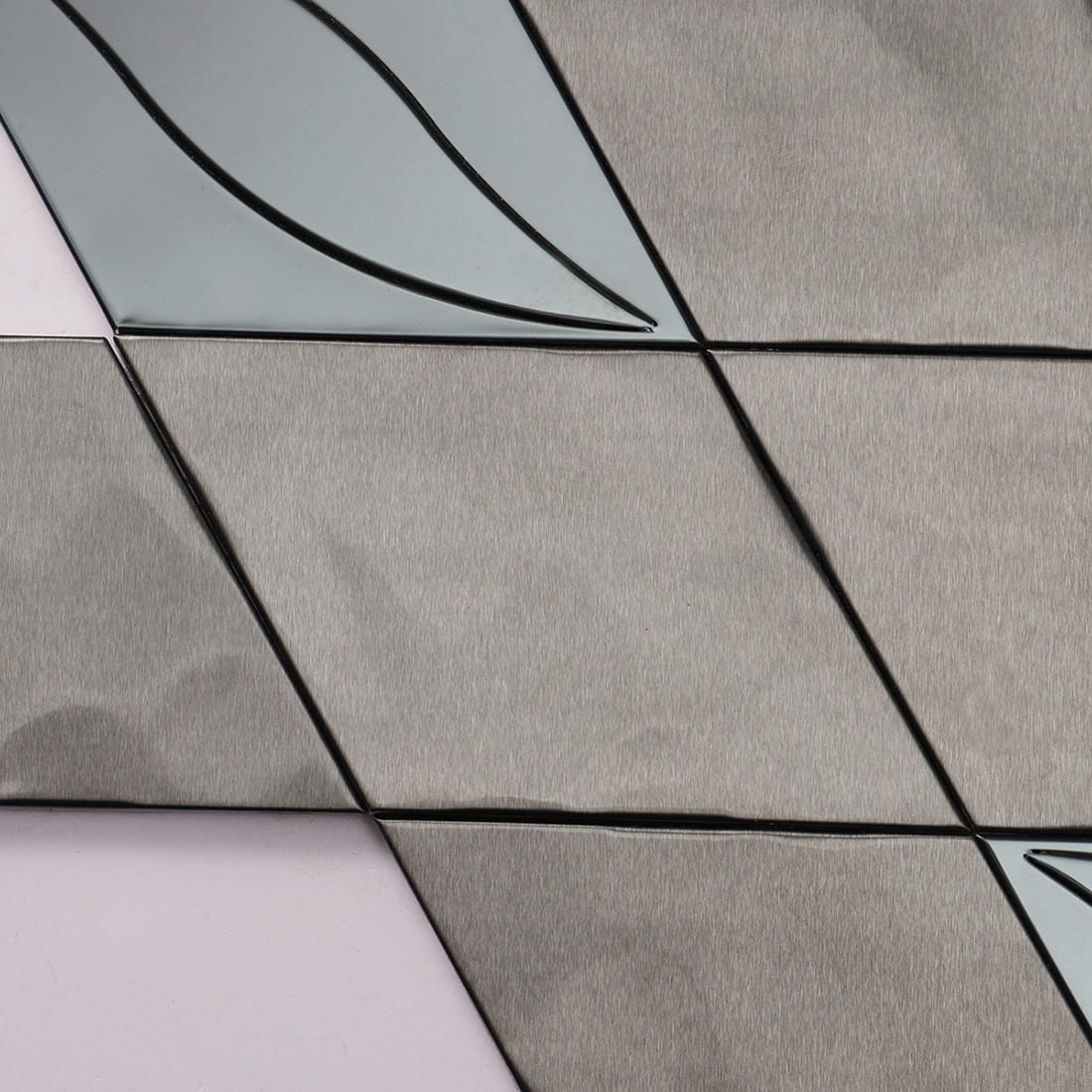 Close-up focusing on the metallic texture of black brushed stainless steel diamond tiles.