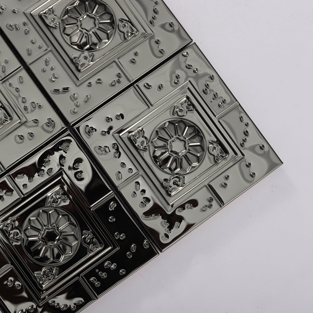 Corner detail of black embossed square metal mosaic tiles