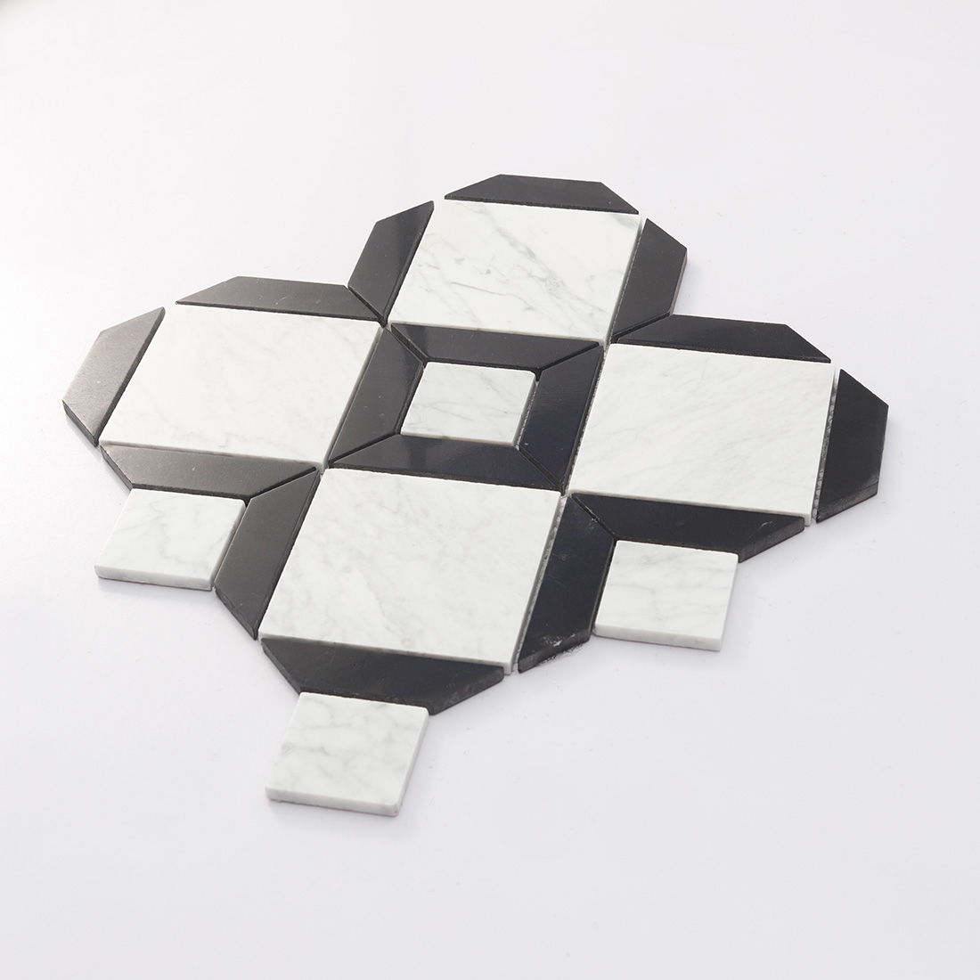 Low angle display of black framed white marble mosaic with raised stone pieces