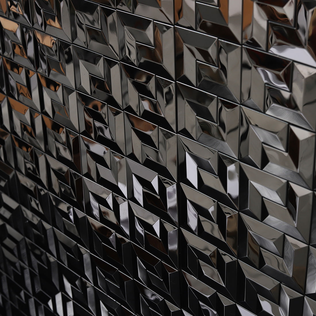 Close-up wall view of black geometric 3D metal mosaic tiles