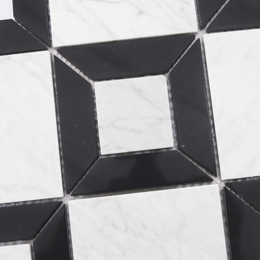 Detail of black geometric frame around white marble square tile pieces