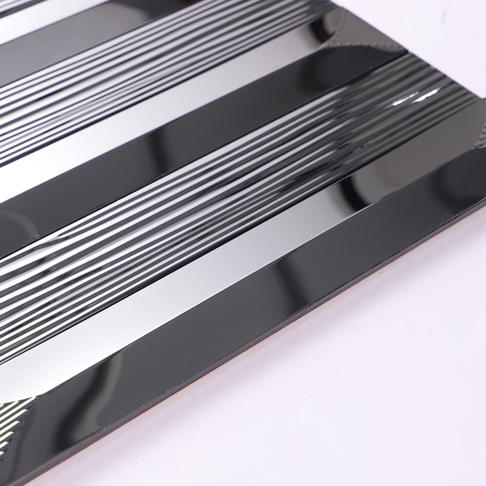 Edge view of black glossy textured rectangular metal mosaic tile sheet