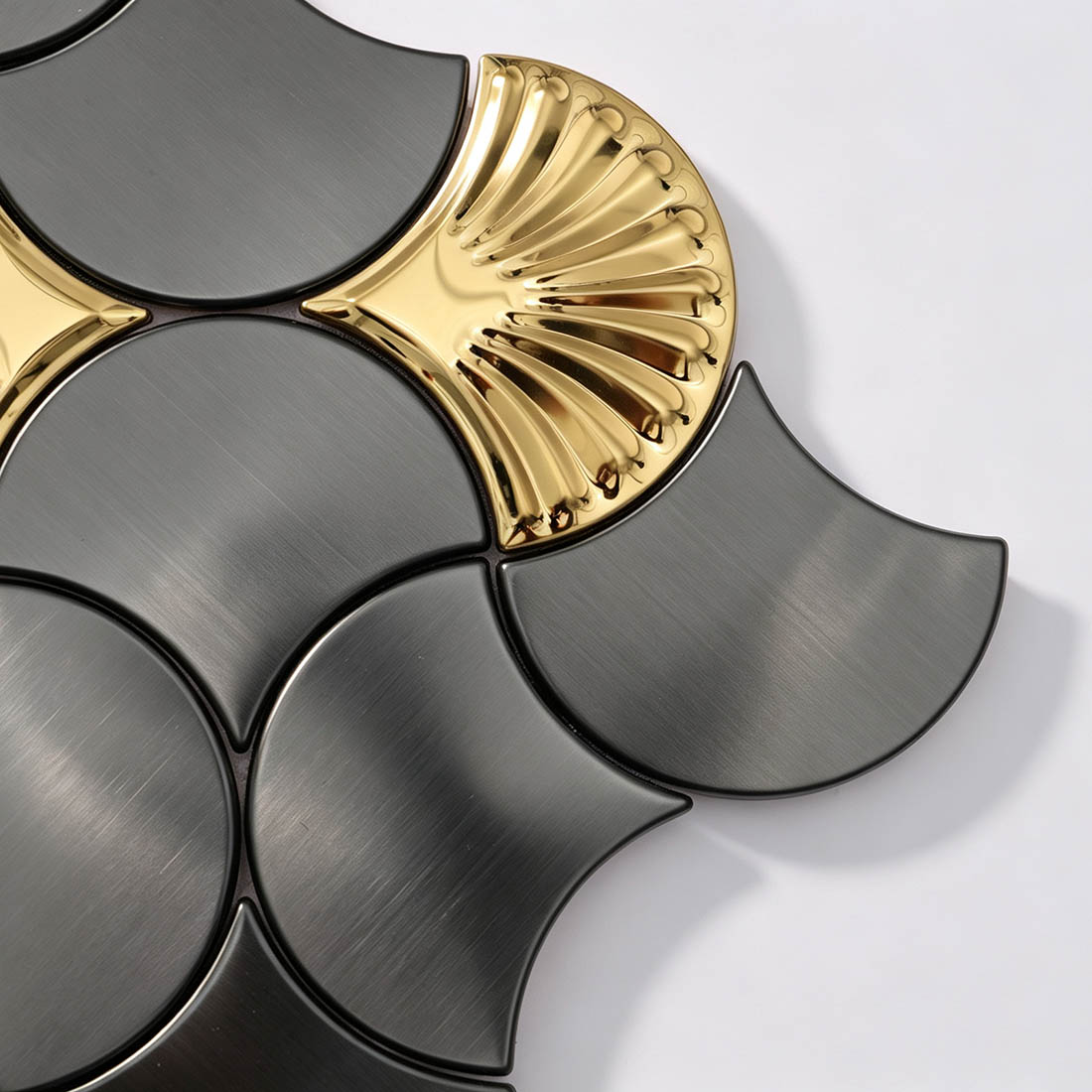 Angled view of black and gold fish scale metallic mosaic tile