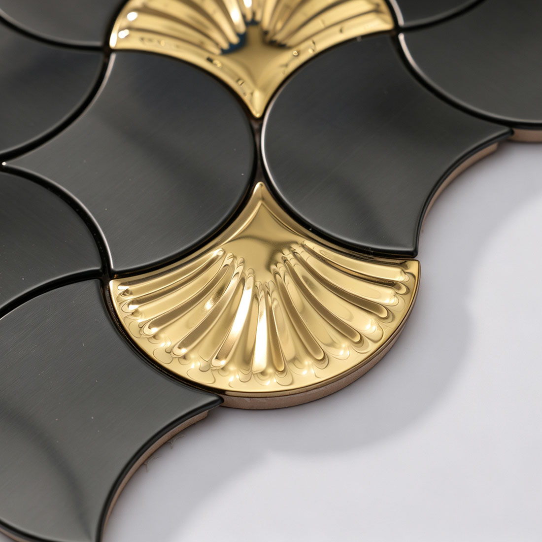 Edge detail of black and gold fish scale metallic mosaic tile