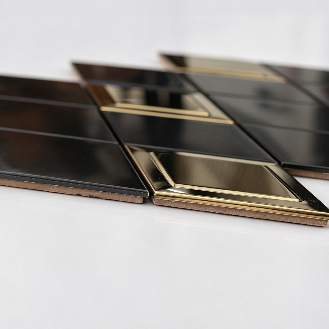 Side view of black and gold rhombus metal mosaic tiles showing the layered base