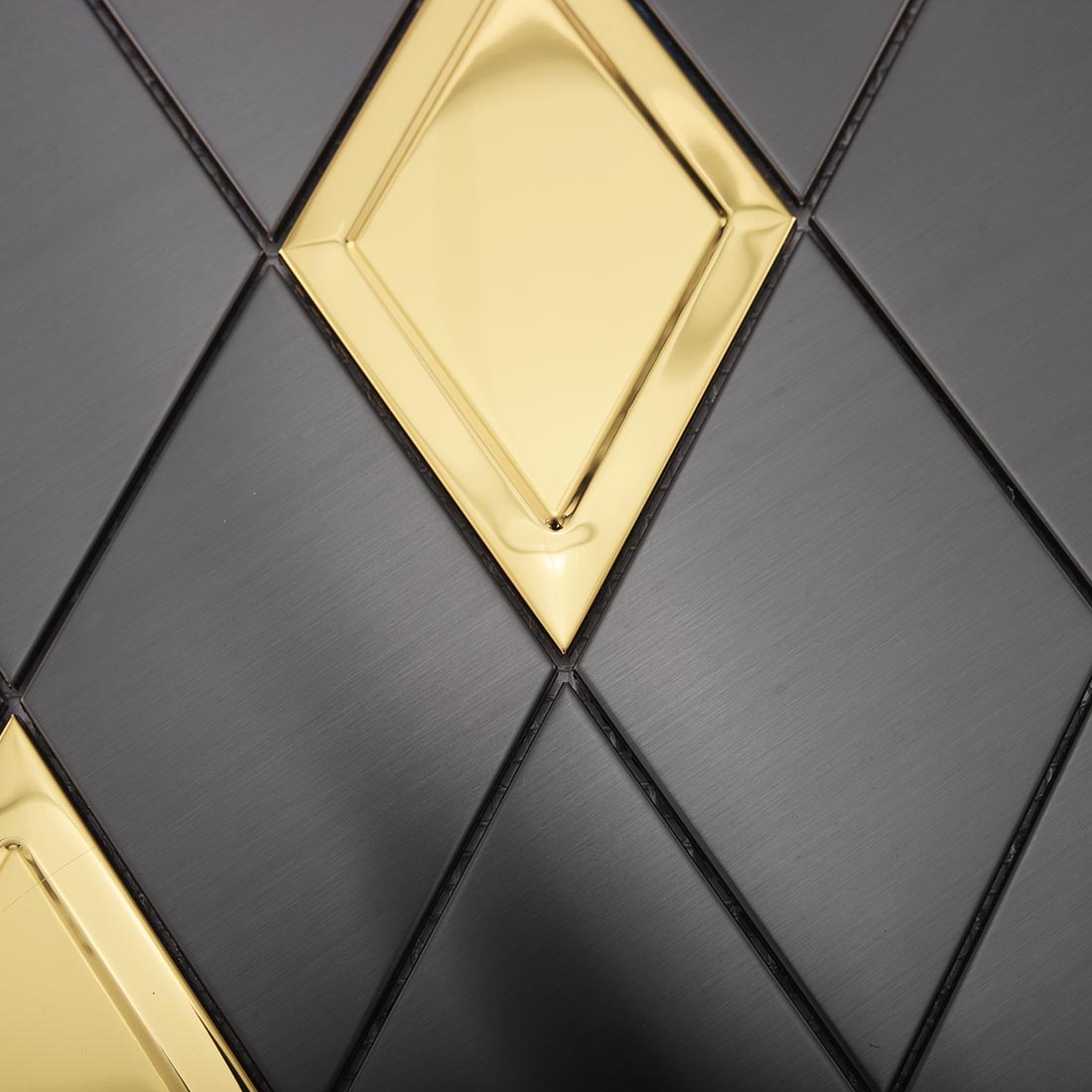 Detailed view of black brushed rhombus mosaic tiles with raised gold accents