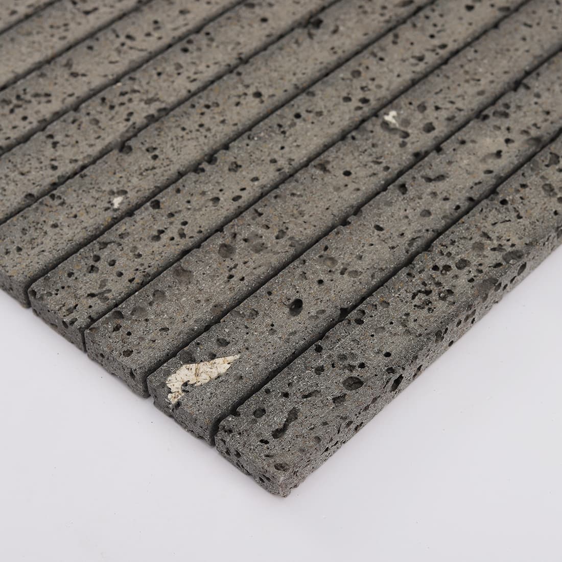 Angled edge view of black lava stone fluted mosaic tile