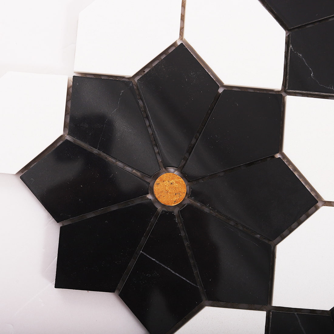 Close up of black marble flower mosaic with small brass dot center