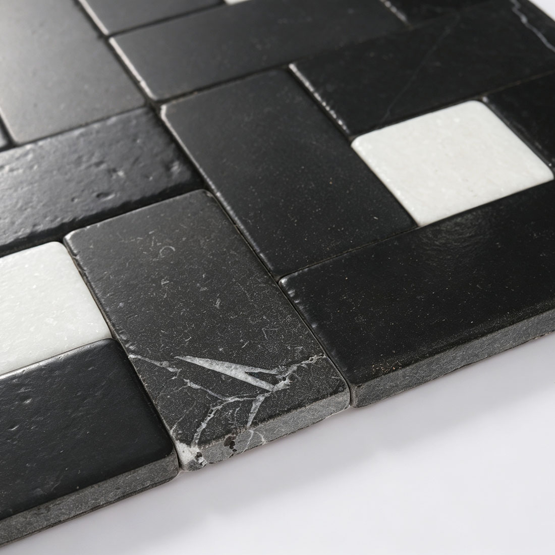 Macro shot of black marble tile edge showing natural white veining