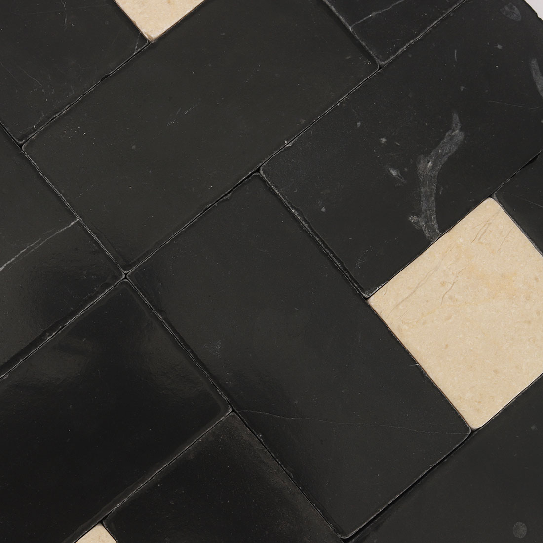 High angle surface texture shot of black and beige pinwheel mosaic