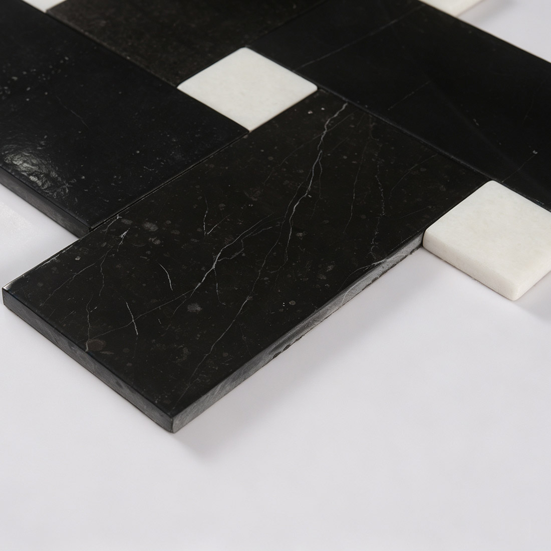 Macro view of black marble strip and white accent dot tile edge