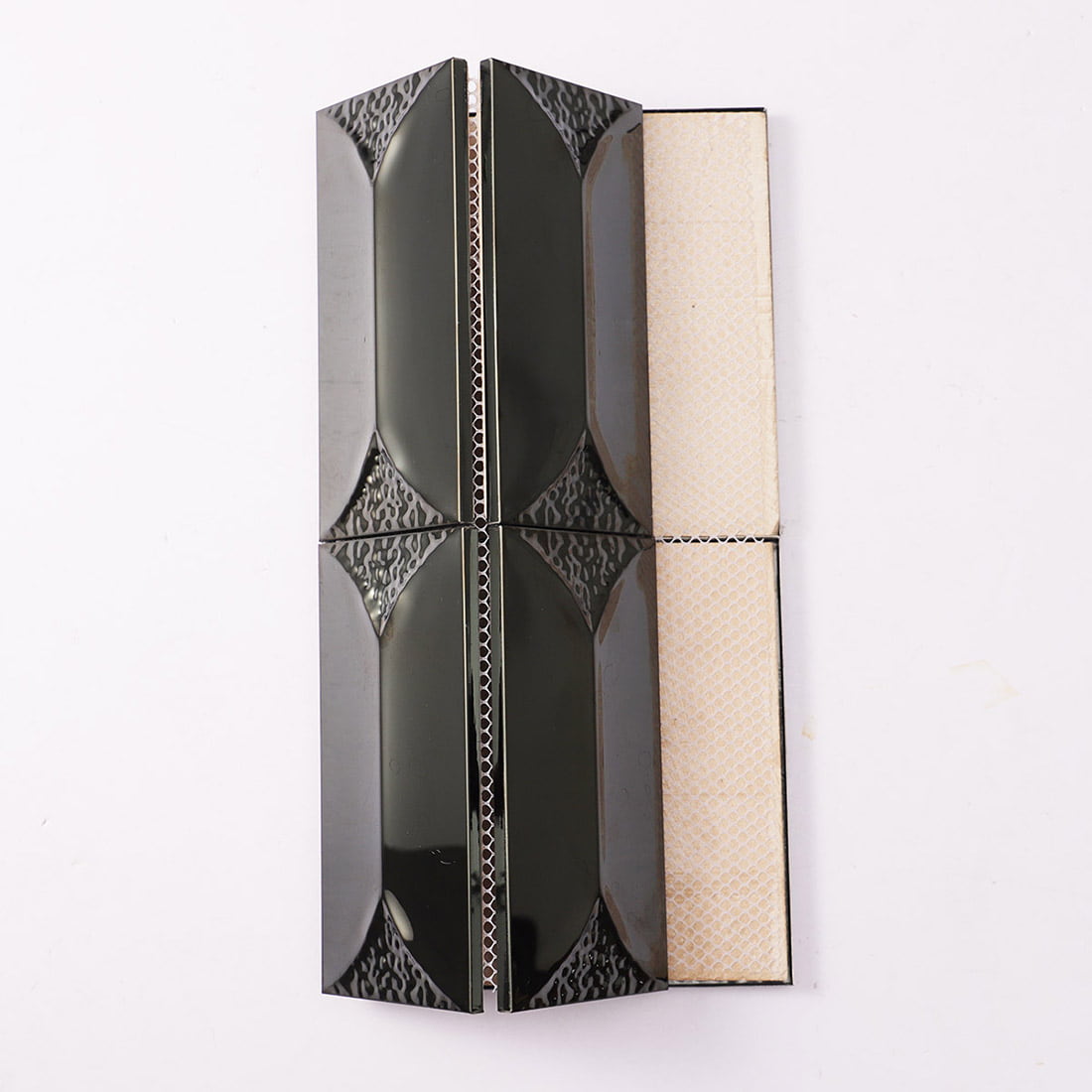 Display of black metal mosaic tiles showing the fiber mesh backing.